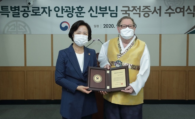 추미애 법무부 장관(왼쪽)이 24일 정부과천청사에서 개최된 ‘국적증서 수여식’에서 ‘안광훈’ 신부에게 특별공로자 국적증서를 수여 후 기념촬영 하고 있다.(사진제공=법무부)