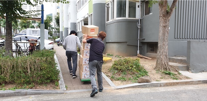 25일 법무부 구미준법지원센터 사회봉사자들이 황상3주공아파트 단지 내에서 추석맞이 ‘사랑의 선물’을 운반하고 있다.(사진제공=구미준법지원센터)
