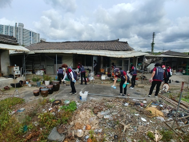 온양 여성의용소방대가 취약계층 주택 안팎 대청소를 하고 있다.(사진제공=온산소방서)