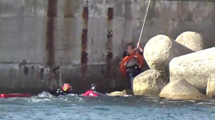 구조대원이 추락한 낚시객을 구조하고 있다.(사진제공=부산해양경찰서)