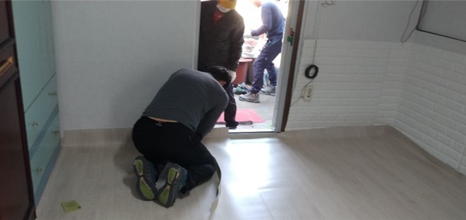 전기설비 특기를 가진 사회봉사대상자들이 장판을 교체하고 있다.(사진제공=논산준법지원센터)