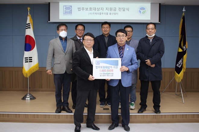 국제피플투피플 울산챕터 전우수 회장이 법무보호복지공단김주병 지부장(우측)에게 지원금을 전달하고 기념촬영.(사진제공=한국법무보호복지공단울산지부)