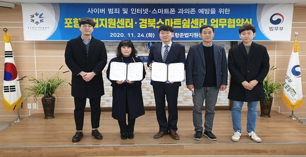 포항준법지원센터와 경북스마트쉽센터가 11월 24일 업무협약서를 내보이며 기념촬영. (사진제공=포항준법지원센터)