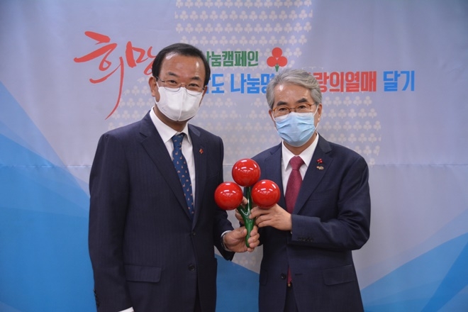 강기철 공동모금회장이 박종훈 교육감(사진우측)에게 사랑의 열매를 달아주고 기념촬영.(사진제공=경남사랑의열매)