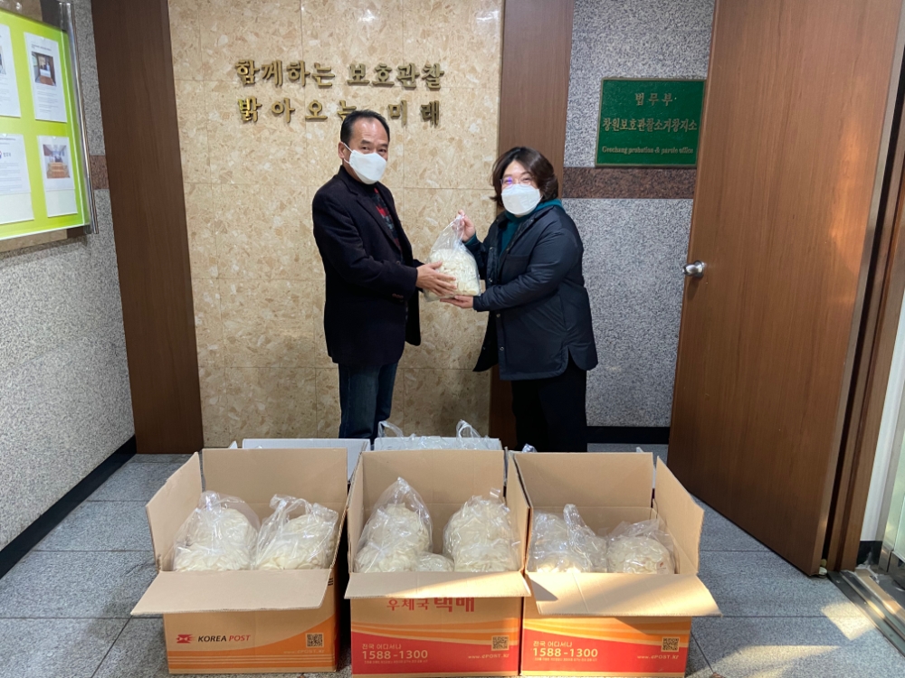 보호관찰위원 거창지역협의회 이미란 사무국장이 사랑의 떡국떡 전달하고 있다.(사진제공=거창준법지원센터)