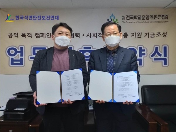 석면연대 최완재 대표(사진왼쪽)와 전국학운위 구교선 회장이 3월 5일 업무협약서를 내보이며 기념촬영.(사진제공=한국석면안전보건연대)