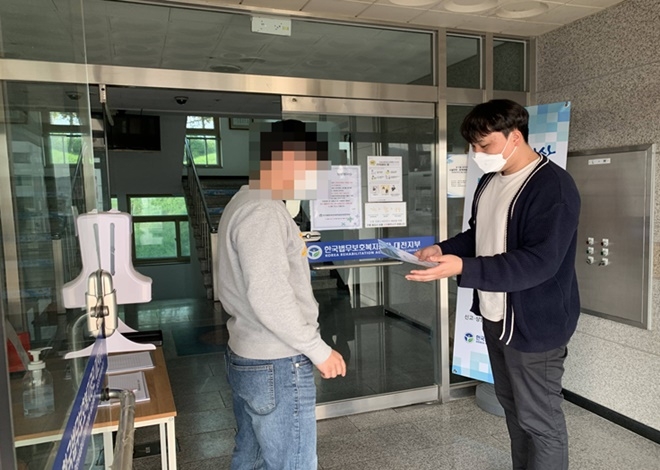 공단 직원이 기관을 방문한 민원인에게 안내문과 함께 청렴실명제를 설명하고 있다.(사진제공=한국법무보호복지공단 대전지부)