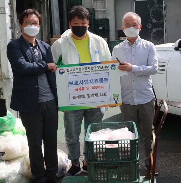 부산지부 정순찬 과장(사진 왼쪽)과 놀라푸드 정익채 대표(가운데)가 보호사업지원물품 전달 기념촬영을 하고 있다.(사진제공=한국법무보호복지공단 부산지부)