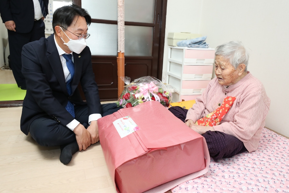 김현준 LH 사장이 어르신에게 기념품과 꽃바구니를 전달하고 있다.(사진=LH)