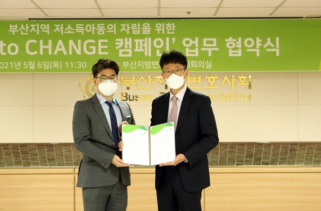 부산지역 저소독아동의 자립을 위한 Chance to Change 캠페인 업무협약서를 내보이며 기념촬영.(사진우측 황주환 회장). (사진제공=부산지방변호사회)