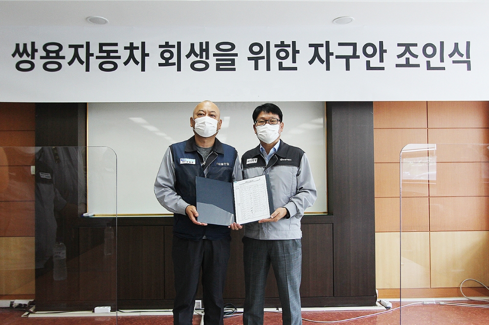 정용원 관리인(사진 오른쪽)과 정일권 노동조합 위원장이 합의안에 서명한 후 기념촬영을 하고 있다.(사진=쌍용자동차)