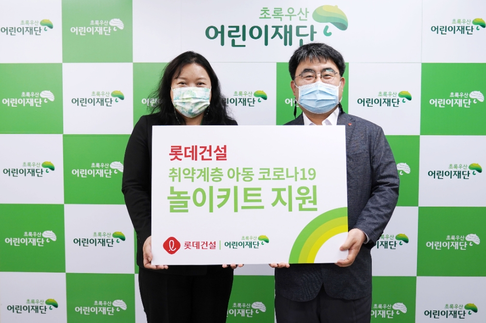 초록우산어린이재단 최운정 본부장과 롯데건설 한정호 상무(오른쪽)가 서울지역 아동을 위한 ‘놀이 키트’ 전달식을 진행했다.(사진=롯데건설)