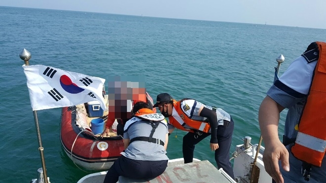 출동한 송정파출소 경찰관들이 레저객을 안전하게 구조하고 있다.(사진제공=부산해양경찰서)