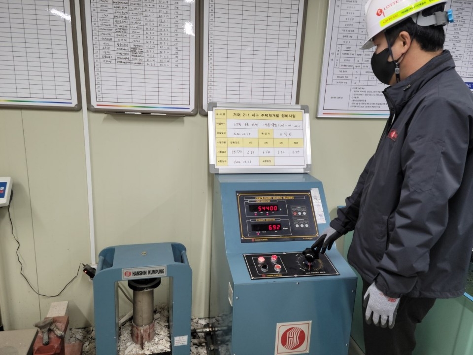 롯데건설이 롯데케미칼, 동남기업과 함께 개발한 화학 혼화제를 현장에 적용해 압축강도 테스트를 하는 모습.(사진=롯데건설)