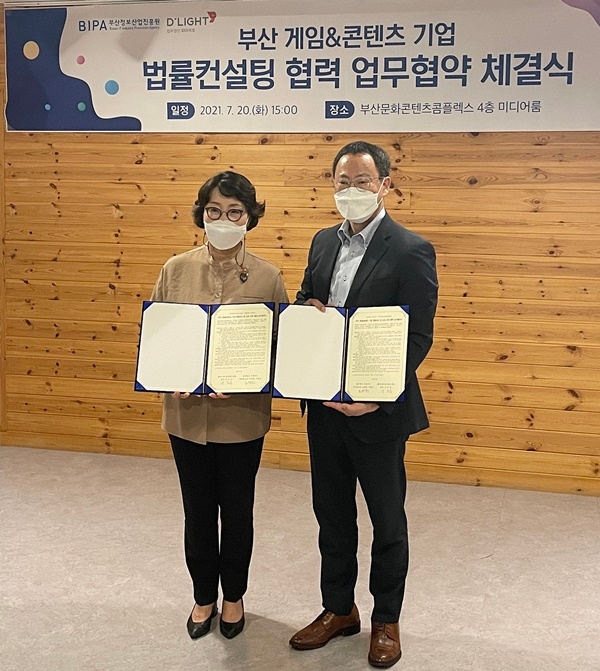 부산정보산업진흥원 이인숙 원장과 법무법인 디라이트 조원희 대표변호사가 협약서를 내보이며 기념촬영.(사진제공=법무법인 디라이트)