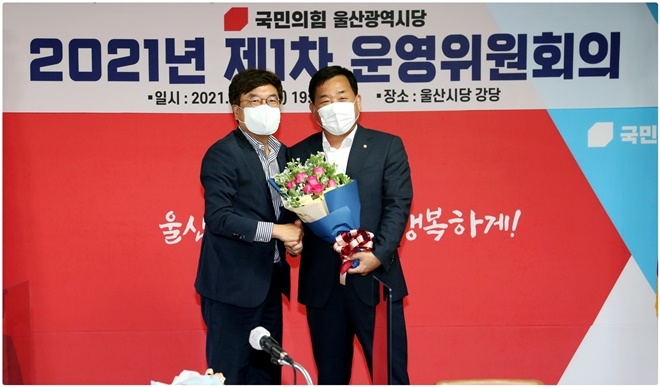 서범수 시당위원장이 박성민 차기 시당위원장(우측)에게 축하의 꽃다발과 함께 축하를 하고 있다.(사진제공=국민의힘 울산시당)