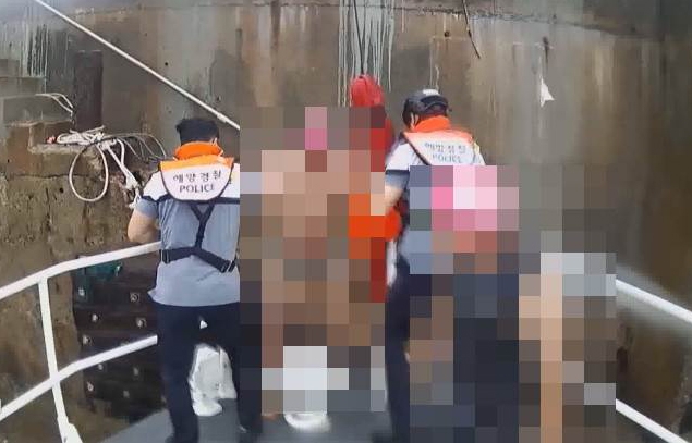 경찰관이 고립자 2명을 구조하고 있다.(사진제공=부산해양경찰서)