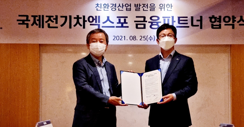 김대환 (사)국제전기자동차엑스포 이사장(왼쪽)과 정지호 신한은행 대기업외환그룹장이 25일 대한상공회의소에서 업무협약을 체결한 후 기념촬영을 하고 있다.