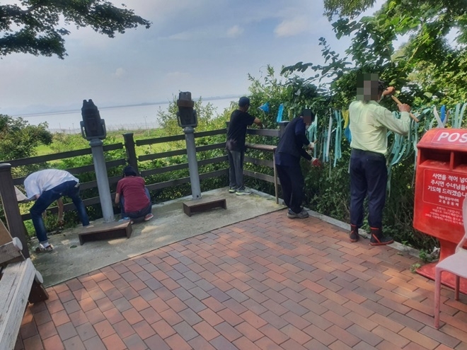 사회봉사대상자들이 망향대에서 제초작업을 하고 있다.(사진제공=인천서부준법지원센터)