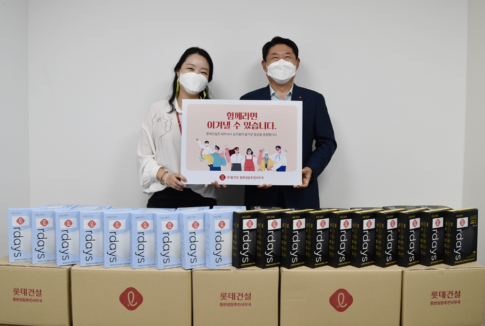 롯데건설이 파트너사를 위해 준비한 마스크(왼쪽-롯데건설 박은병, 오른쪽-외주구매본부장).(사진=롯데건설)