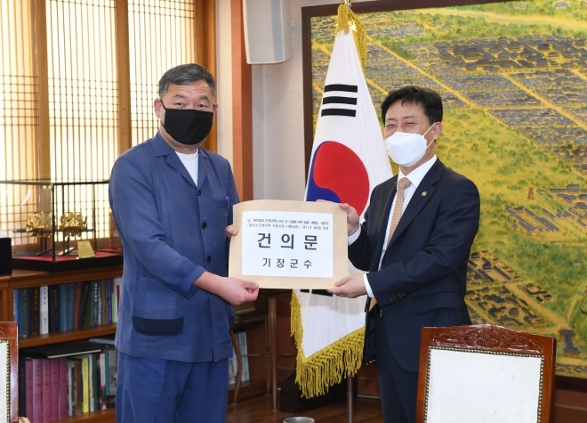 오규석 기장군수(왼쪽)는 11월 3일 ‘원전소재 지방자치단체 행정협의회’ 정기회의에서 박기영 산업통상자원부 2차관에게 송·변전설비 및 발전소 주변지역 주민들에게 원하는 사업이 지원될 수 있도록 관련 법 개정을 요청하는 건의문을 전달하고 기념촬영.(사진제공=부산 기장군)