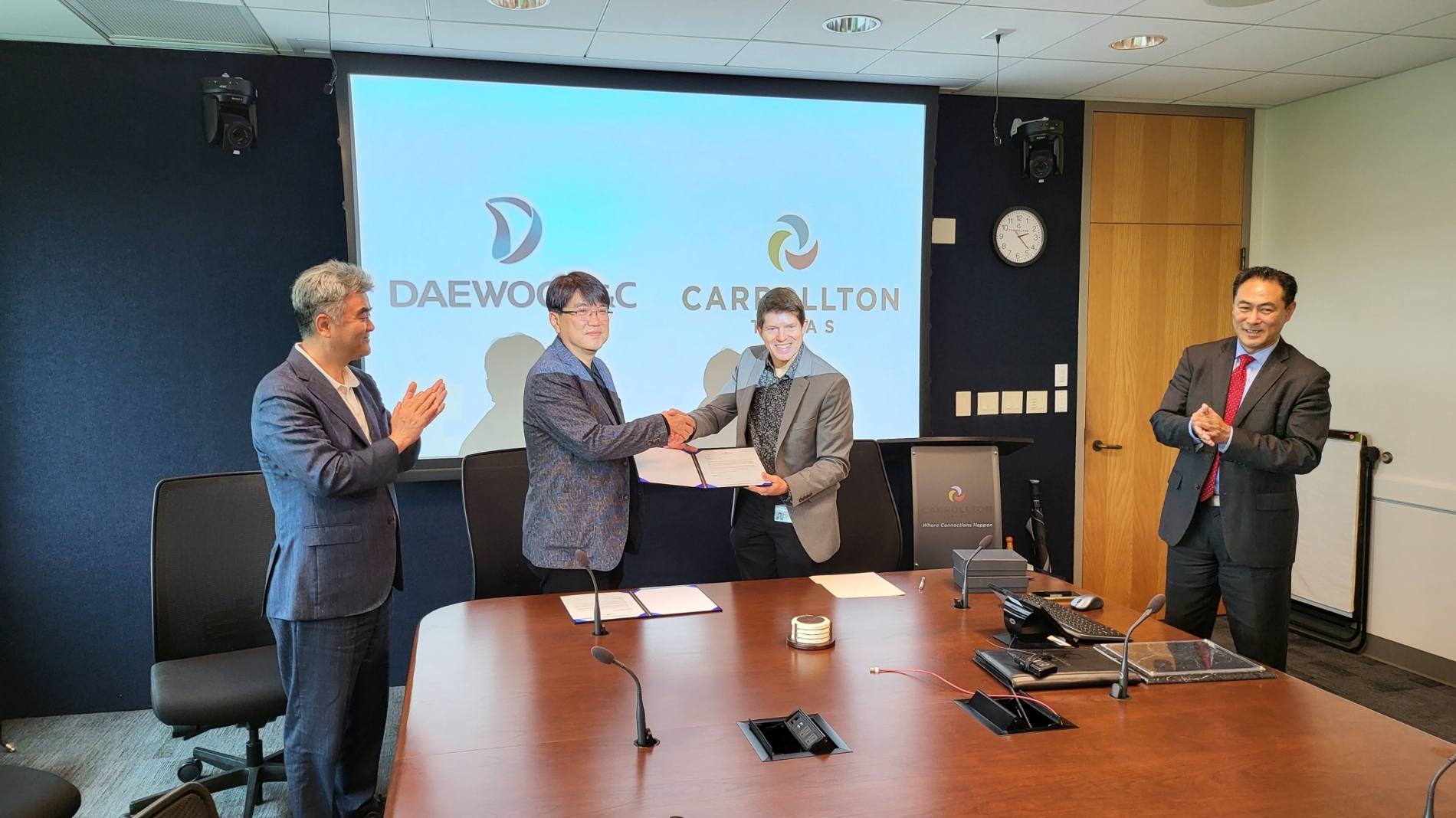 지난 5월 5일 텍사스주 캐럴턴시 의회 회의실에서 캐럴턴시장 Kelvin Falconer(가운데 오른쪽)와 대우건설 한승 신사업추진실장(가운데 왼쪽)이 부지개발사업 관련 업무협약을 체결하고 있다.(사진=대우건설)