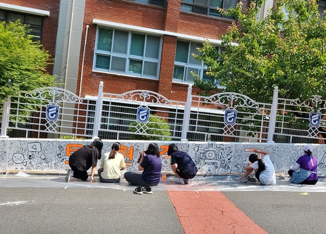 토현중 학생들이 등굣길 담장에 벽화를 그리고 있는 모습.(사진제공=부산교육청)