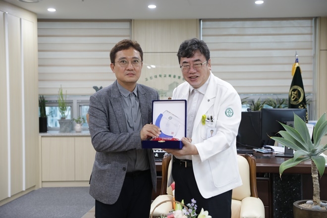 오승경 병원장이 정성수 대표에게 감사패를 전달하고 기념촬영.(사진제공=고신대복음병원)