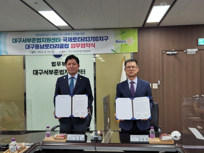 김홍수 대구동남로타리클럽 회장과 김원진 대구서부준법지원센터 소장이 헙무협약서를 내보이며 기념촬영을 하고 있다.(사진제공=대구서부준법지원센터)