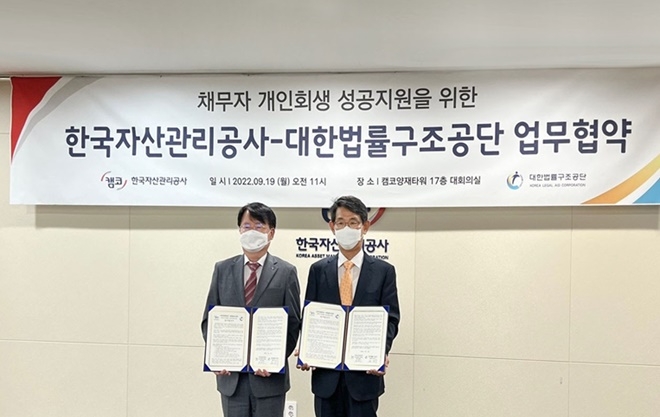 김진수 대한법률구조공단 이사장(오른쪽)과 김귀수 캠코 가계지원본부장이 업무협약을 체결한 뒤 기념촬영 하고 있다.(사진제공=대한법률구조공단)