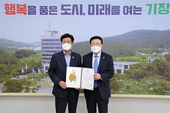 정종복 기장군수(왼쪽)가 기장군 명예회장으로 위촉받고 서정의 회장과 기념촬영.(사진제공=대한적십자사 부산지사)