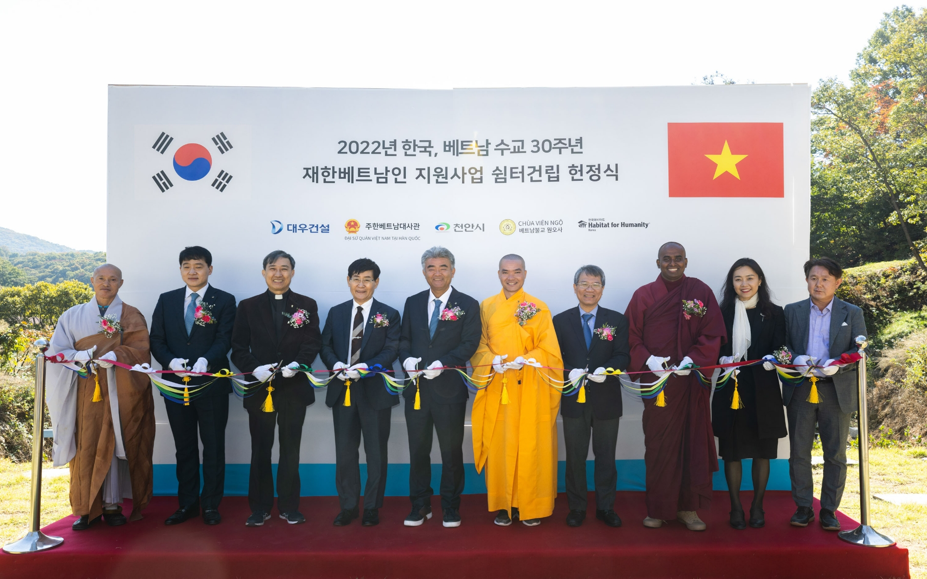 정식에 참여한 주요 인사들이 테이프 커팅을 하고 있다. (왼쪽부터) 네 번째 해비타트 윤형주 이사장, 다섯 번째 정원주 부회장, 여섯 번째 원오사 팃 드엉 탄 주지스님, 일곱 번째 베트남 응우옌 부 뚱 대사.(사진=대우건설)