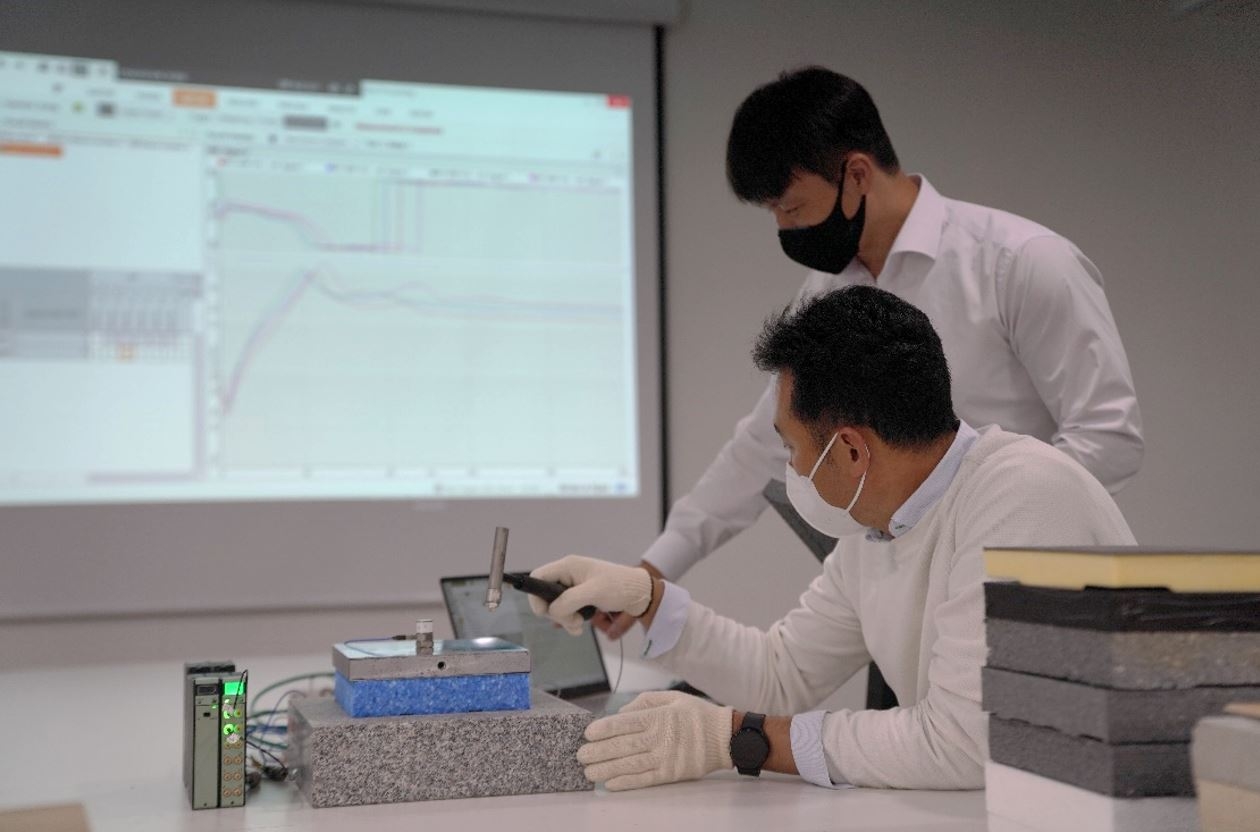 롯데건설 관계자가 층간완충재 실험 결과를 확인하고 있는 모습.(사진=롯데건설)