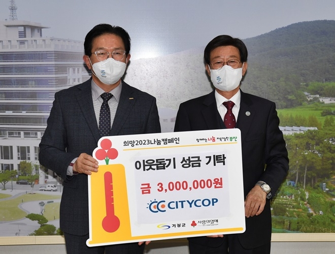 ㈜시티캅 정형돈 대표이사(사진왼쪽)가 정종복 기장군수에게 이웃돕기 성금을 전달하고 기념촬영.(사진제공=부산 기장군)