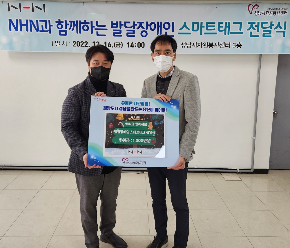 성남시 자원봉사센터 김재성 사무국장(사진 왼쪽)과 NHN 김재환 대외정책실장(사진 오른쪽)이 발달장애아동 사고 예방을 위한 스마트 태그 전달식을 마치고 기념촬영을 하고 있는 모습. 사진=NHN