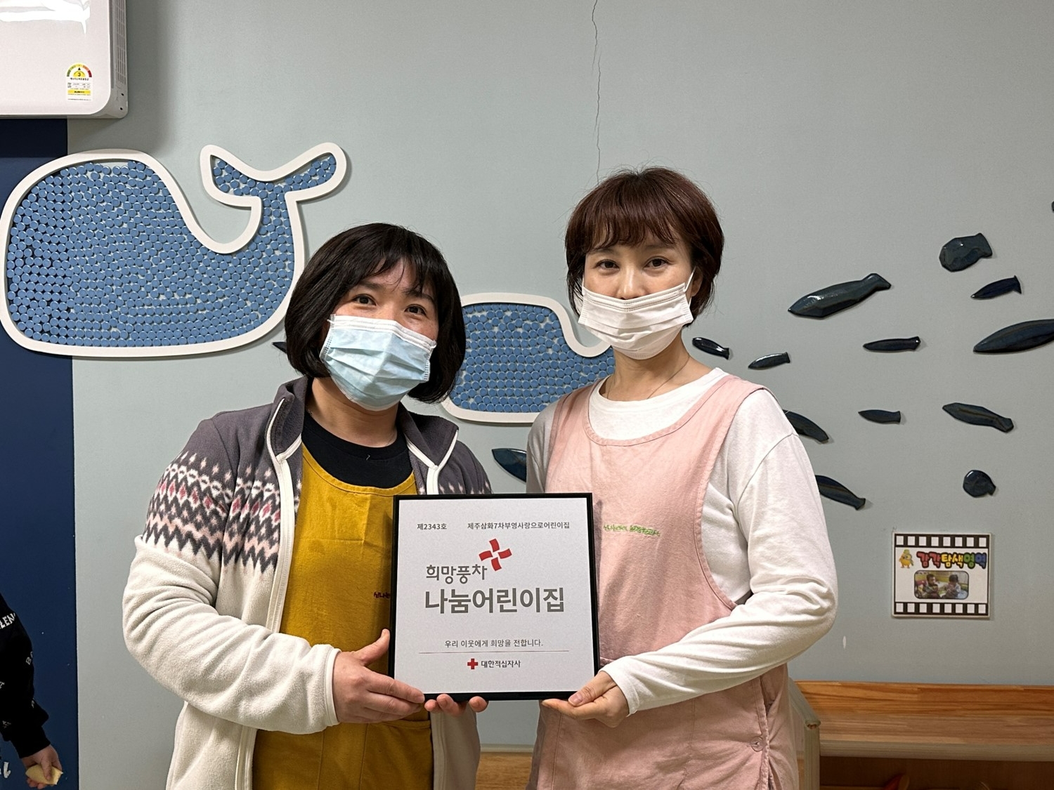 김은애 제주삼화7차 부영 사랑으로 어린이집 원장(오른쪽)이 대한적십자사 관계자와 기념촬영을 하고 있다.(사진=부영그룹)