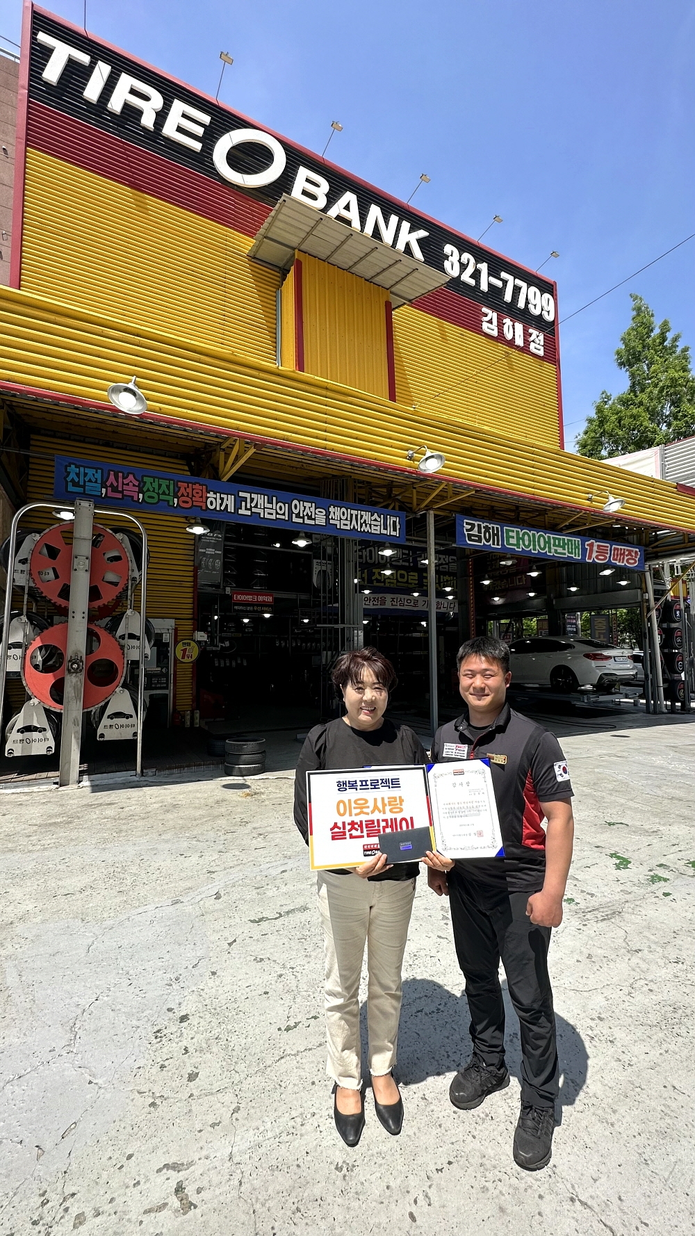 경남여성리더봉사단 김경희 회장(왼쪽)과 타이어뱅크 김해전 김상민 사업주(오른쪽)가 감사장, 타이어 교환권 전달 후 기념 촬영을 하고 있다.(사진=타이어뱅크)
