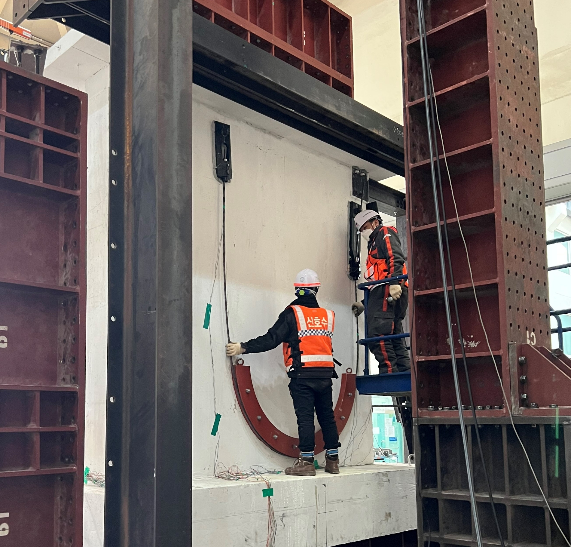 DL이앤씨 직원들이 수직증축 리모델링의 안전성 문제를 해결할 수 있는 ‘포스트텐션(Post-Tension) 하중전이공법’을 국내 건설업계 최초로 개발해 검증하고 있다.(사진=DL이앤씨)