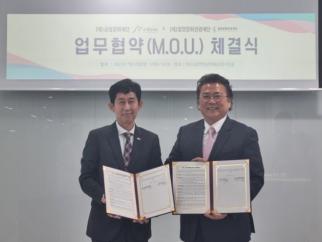 이치우 밀양문화관광재단 대표이사(사진왼쪽)와 이홍길 부산 금정문화재단 상임이사가 업무협약서를 내보이며 기념촬영.(사진제공=부산금정문화재단)