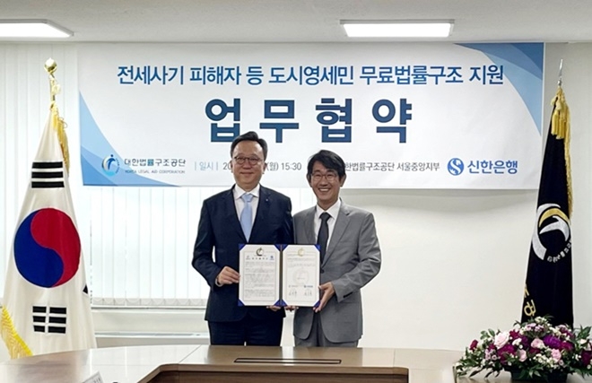 김진수 대한법률구조공단 이사장(오른쪽)과 정상혁 신한은행장이 업무협약서를 내보이며 기념촬영을 하고 있다.(사진제공=대한법률구조공단)