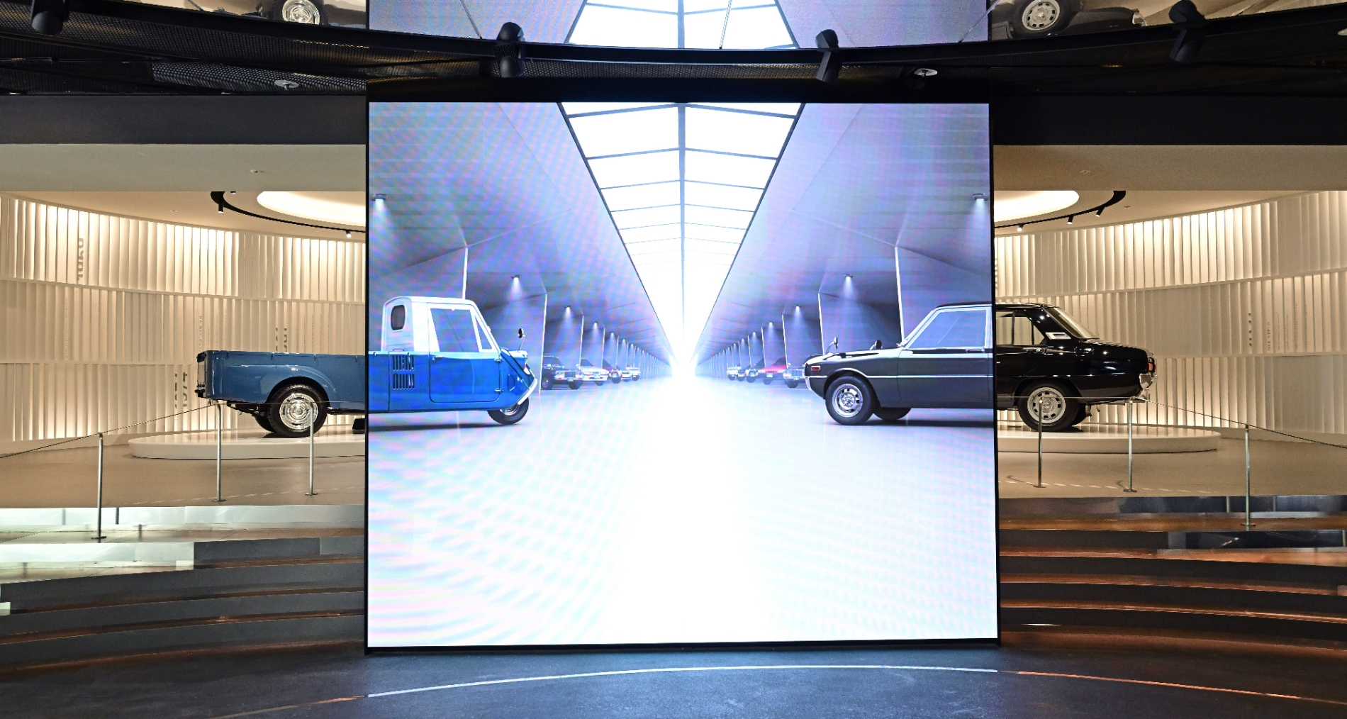 기아 T-600, 브리사 복원 모델 앞에 역대 기아 대표 모델들의 이미지가 연출된 모습.(사진=기아)