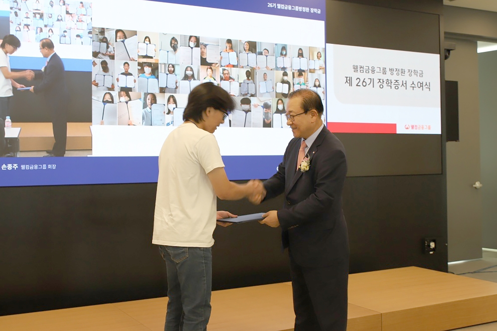 웰컴금융그룹 손종주 회장(오른쪽)이 장학생에게 장학증서를 수여하고 있다. 사진=웰컴금융그룹