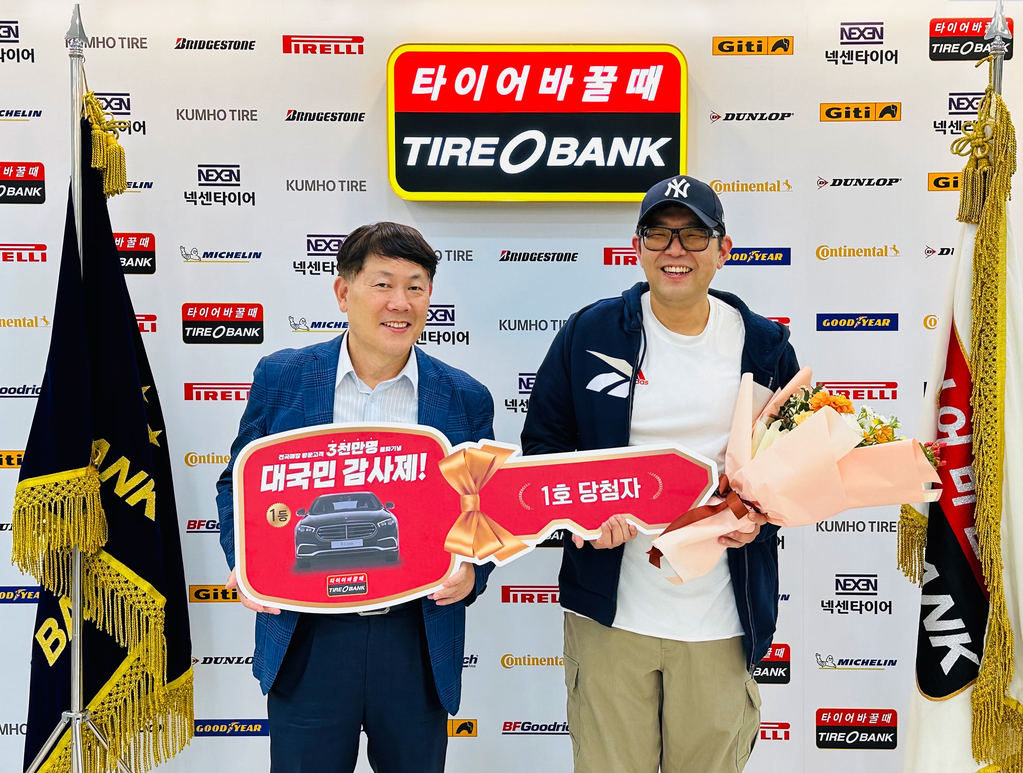 세종특별자치시 어진동에 있는 타이어뱅크 본사에서 김정규 회장(좌)과 대국민감사제 1호 주인공인 심영태(우)씨가 기념 촬영을 하고 있다.(사진=타이어뱅크)