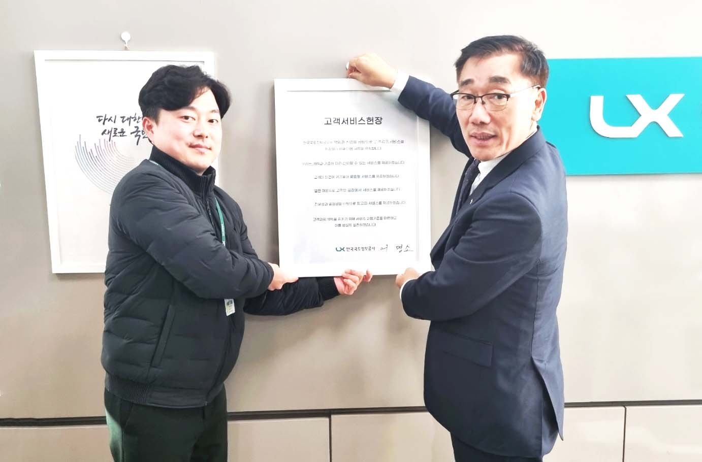 LX공사 어명소 사장(오른쪽)과 LX 직원이 지난달 30일. LX화성지사에서 개정된 고객서비스헌장을 게시하고 있다.(사진=LX공사)
