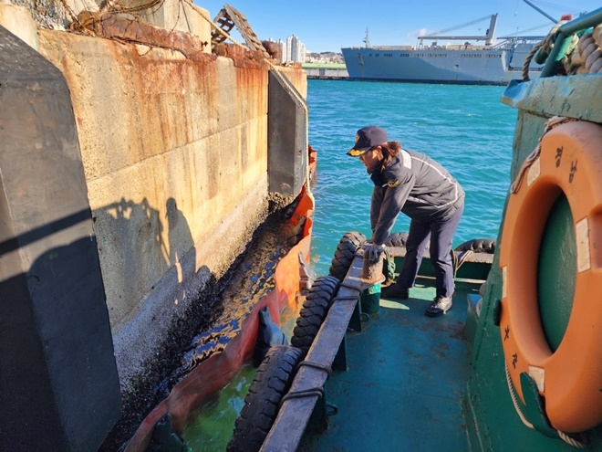 부산해경 황선주 해양오염방제과장이 22일 기름 유출 사고 관련, 북항 7부두 내 오염물질을 확인하고 있다.(사진제공=부산해양경찰서)