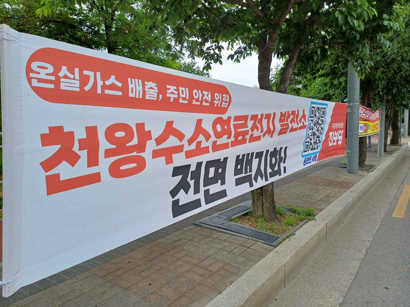 천왕지구 주민들이 천왕차량기지 옆 도로에 내건 수소연료전지 발전소 전면 백지화 플랜카드. (사진=로이슈)