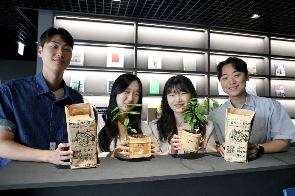 집씨통 캠페인에 참여한 DL이앤씨 직원들이 도토리 화분을 선보이고 있다.(사진=DL이앤씨)