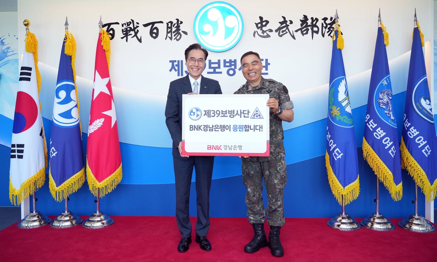 BNK경남은행 예경탁 은행장(사진 왼쪽)이 제39보병사단 김종묵 사단장에게 ‘위문금 증서’를 전달하고 있다. 사진=BNK경남은행