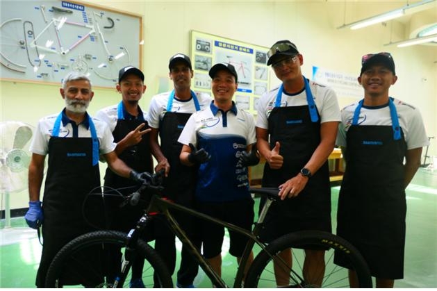경정훈련원에서 해외 선수, 지도자들이 자전거 정비 실습을 하며 기념사진을 촬영하고 있다.(사진=국민체육진흥공단)