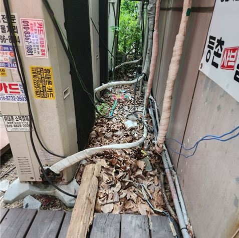 미관광장4호 주변 상가뒷쪽 각목과 잡쓰레기가 방치되어 있다.